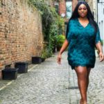 Olakemi - A curvy plus size model wearing a plus size blue feather dress