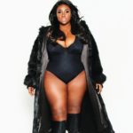Olakemi - A curvy plus size model wearing a plus size one piece black swimsuit