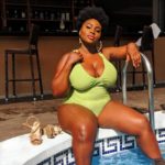 Olakemi - A curvy plus size model wearing a bright green plus szie one piece swimsuit by @fashionnovacurve