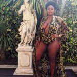 Olakemi - A Curvy Plus size model wearing a plus size gold and black one piece swimsuit from @fashionnovacurve