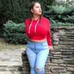 Plus size model Costina Ana-Maria Munteanu - @costina​_got_curves modeling a red plus size hoodie and ripped/torn plus size jeans