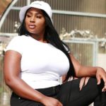 Olakemi - A curvy plus size model wearing a plus size white top and plus size black jeans by @goodamerican
