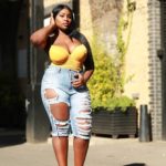 Olakemi - A curvy plus size model wearing a yellow plus size bustier top and plus size rippped jeans by @fashionnovacurve