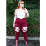 Curvy plus size fitness model Nicole Herring aka @nlhfit modeling plus size ripped red jeans and a plus size white top @fashionnovacurve