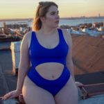 Plus Size Model Sophie Turner wearing a plus size one piece blue swimsuit