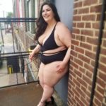 Plus size model Faith Costa (Faith PlusFashion) wearing a black plus size swimsuit